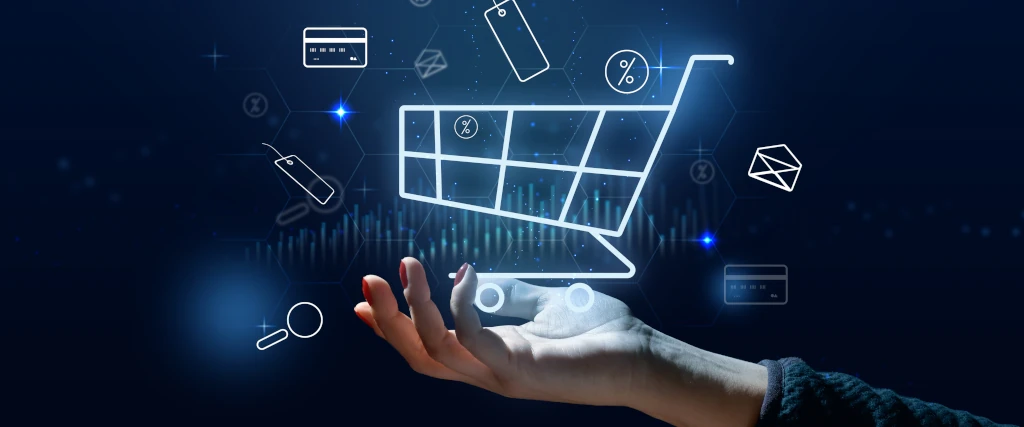 Mano che sostiene un carrello della spesa digitale con icone di e-commerce e tecnologia su sfondo futuristico.